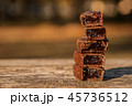 Stack of chocolates on wooden background in park. 45736512