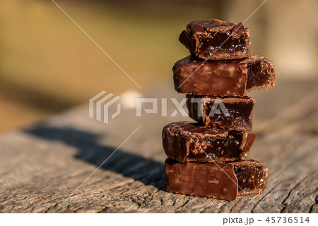 Chocolates filled with marmalade on wooden bench. Chocolates filled with marmalade on wooden bench. 45736514