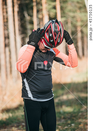 Training an athlete on the roller skaters. Biathlon ride on the roller skis with ski poles, in the 45750135