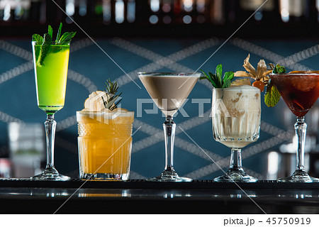 row of various colourfull alcoholic cocktails on a bar desk. Glasses of differen shapes 45750919