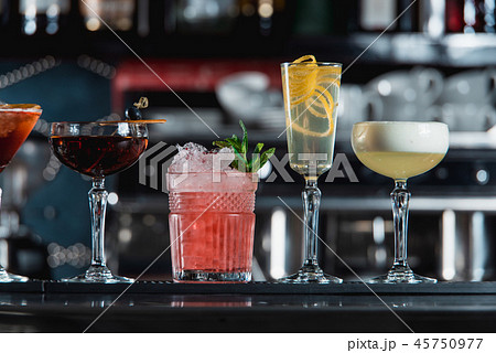 row of various colourfull alcoholic cocktails on a bar desk. Glasses of differen shapes 45750977
