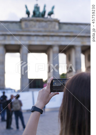 Hands holding phone mobile and takes pictures of Brandenburg Gat 45759230