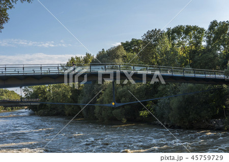 Pedestrian bridge over the stormy river in the evening 45759729