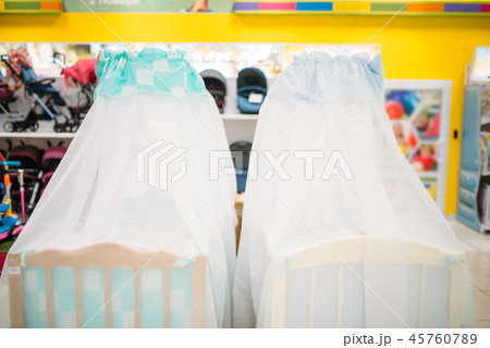 Two wooden baby cots in store, nobody Two wooden baby cots in store, nobody 45760789