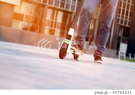 Close up image of a man on an electric scooter. 45765235