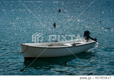 A white motor boat that is moored on the sea. A white motor boat that is moored on the sea. 45765817
