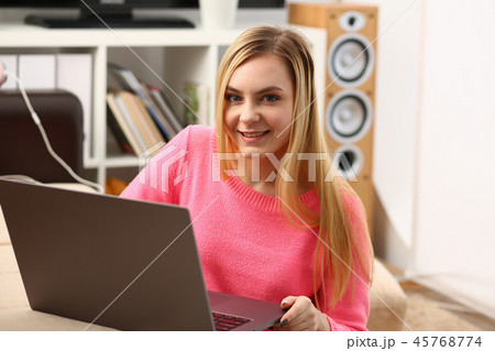 young beautiful blond woman sit in livingroom work on laptop 45768774