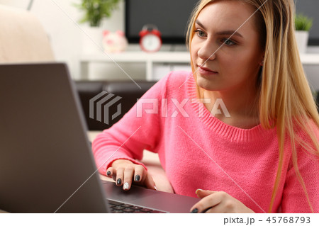 young beautiful blond woman sit in livingroom work on laptop 45768793