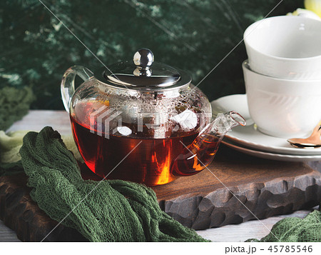 Hot tea in glass tea pot over green background Hot tea in glass tea pot over green background 45785546