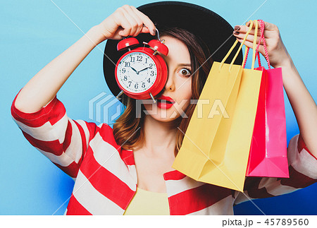 woman with alarm clock and shopping bags woman with alarm clock and shopping bags 45789560