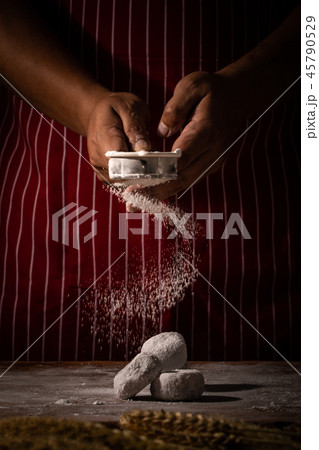 Chef spreading flour on bakery. 45790529