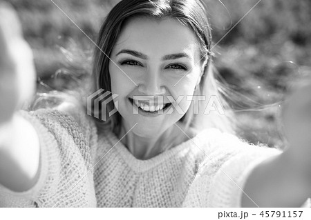 Smiling young woman makes selfie and enjoying nature in autumn season. 45791157