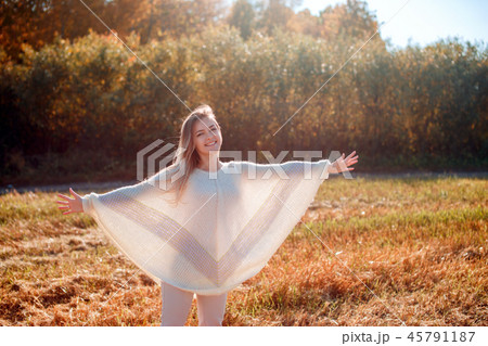 Cheerful girl with raised hands on the field in warm autumn season. Cheerful girl with raised hands on the field in warm autumn season. 45791187