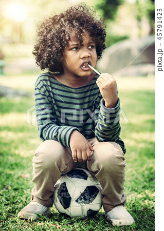 African american child eating snack stick. African american child eating snack stick. 45791423