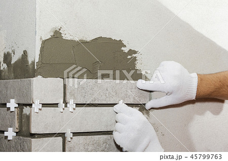 Laying Ceramic Tiles. The Builder makes repairs. 45799763