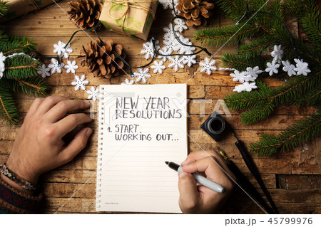 Man writing new year resolution on paper 45799976