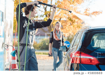 Service man helping woman cleaning her auto in car wash Service man helping woman cleaning her auto in car wash 45800669