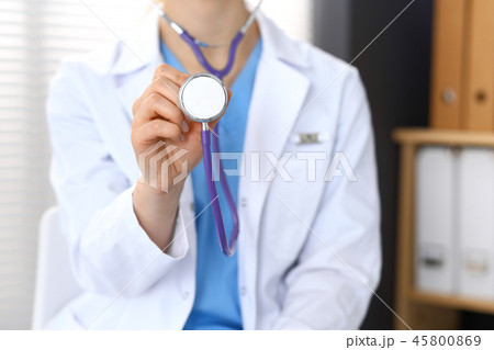 Doctor holds stethoscope head, closeup. Physician ready to examine and help patient. Medical help 45800869