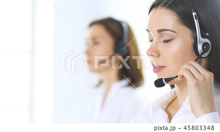 Group of call center operators at work. Focus on beautiful business woman in headset Group of call center operators at work. Focus on beautiful business woman in headset 45803348