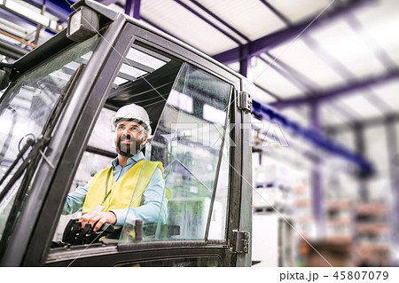 Mature industrial man engineer sitting in a forklift in a factory. 45807079