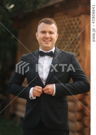 Happy groom in wedding suit stand outside. Handsome man 45808641