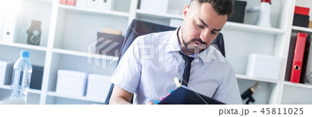 A man is sitting in the office and scrolls through the documents. 45811025