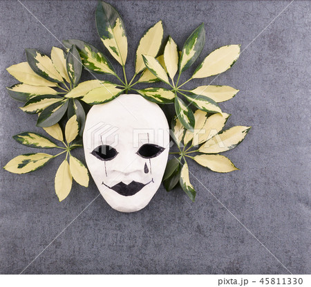 Stylized mask and tropical palm leaves on gray  45811330