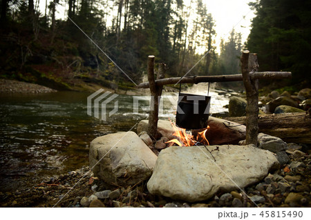 Cooking food in pot over campfire outdoor 45815490