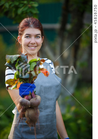 Image of young woman with beetroot in garden 45816750