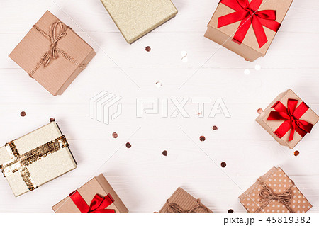 Christmas craft gift boxes create round frame on white wooden background. Christmas craft gift boxes create round frame on white wooden background. 45819382
