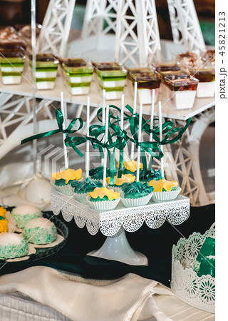 green style wedding candy bar on a white table. cupcakes decorated with a green ribbon bow 45821213