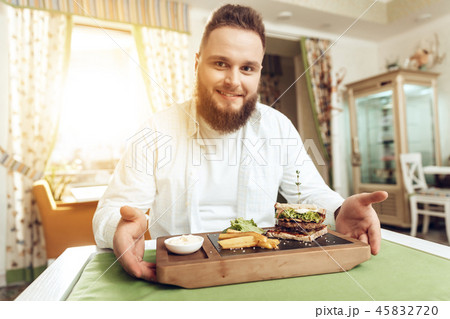Portrait of man eating in cafe and enjoying food Portrait of man eating in cafe and enjoying food 45832720