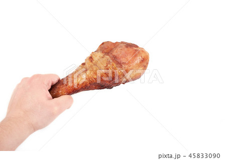 Close up and isolated image of hand holding a grilled turkey leg on white background. Close up and isolated image of hand holding a grilled turkey leg on white background. 45833090
