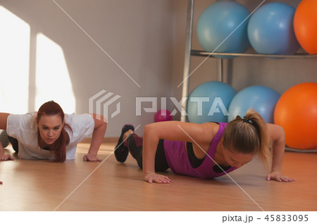 Young positive women exercising in fitness class. Young positive women exercising in fitness class. 45833095