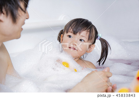 お父さんと一緒にお風呂に入る幼い女の子 親子 父子 娘 育児 衛生 清潔イメージの写真素材