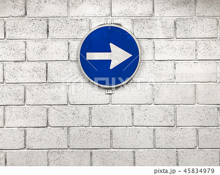 white arrow on blue road sign hanging on wall 45834979