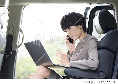 車の中で仕事をする女性の写真素材