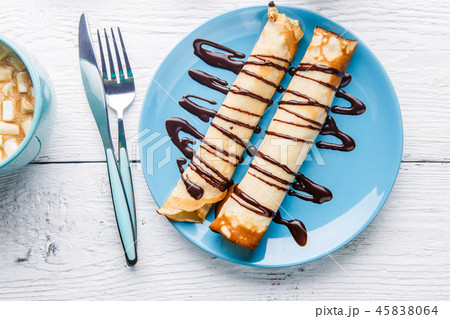 Homemade pancakes or russian blini with chocolate sauce on plate on white wooden background. 45838064