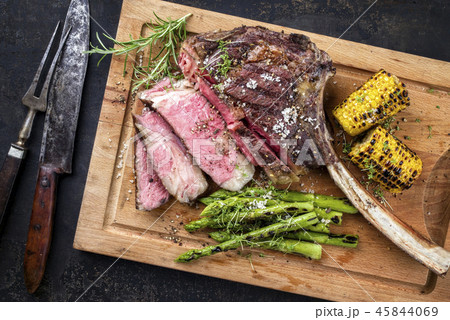 Barbecue Wagyu Tomahawk Steak as top view on burnt Barbecue Wagyu Tomahawk Steak as top view on burnt 45844069