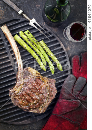 Barbecue Wagyu Tomahawk Steak as top view on burnt Barbecue Wagyu Tomahawk Steak as top view on burnt 45844070