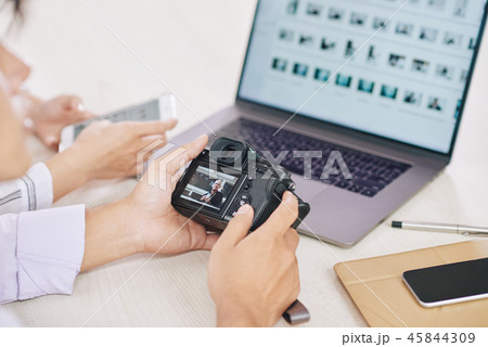 Crop photographers with laptop and camera 45844309