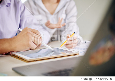 Coworking people watching tablet at desk 45844510