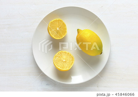 Lemon cut in half on plate with white copy space Lemon cut in half on plate with white copy space 45846066