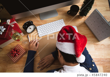 business woman with santa hat sleeping on desk business woman with santa hat sleeping on desk 45847240