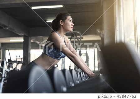 Young asian woman lifting dumbbells in gym.  45847762
