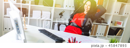 A beautiful young girl leaned back in her office at the table. A beautiful young girl leaned back in her office at the table. 45847893