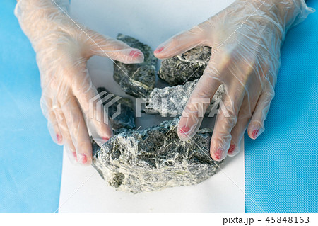 Female hands hold the dangerous mineral asbestos. 45848163