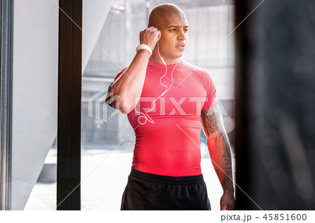 Handsome well built man putting on headphones 45851600