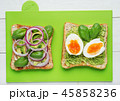 Two avocado toasts on green background 45858236