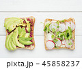 Two avocado toasts on white wooden background 45858237